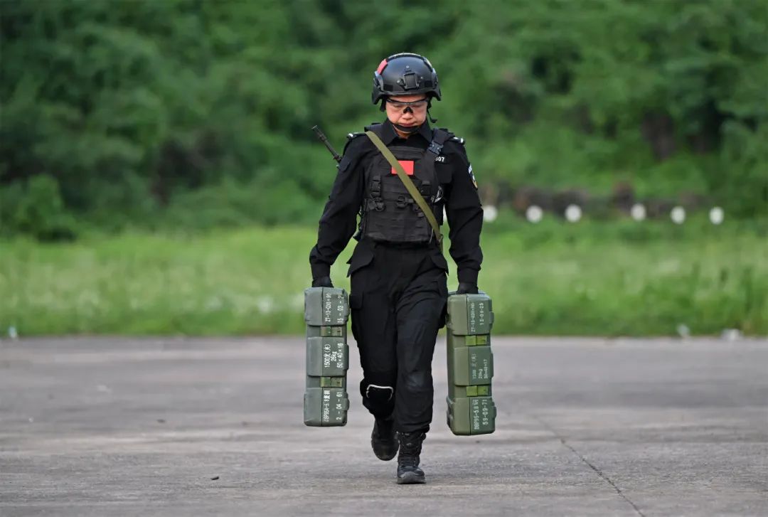 葉霞提著兩個20公斤重的彈藥箱奔跑.JPG